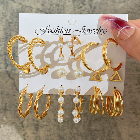 Set of gold and pearl earrings on a 'Fashion Jewelry' card held by a hand.